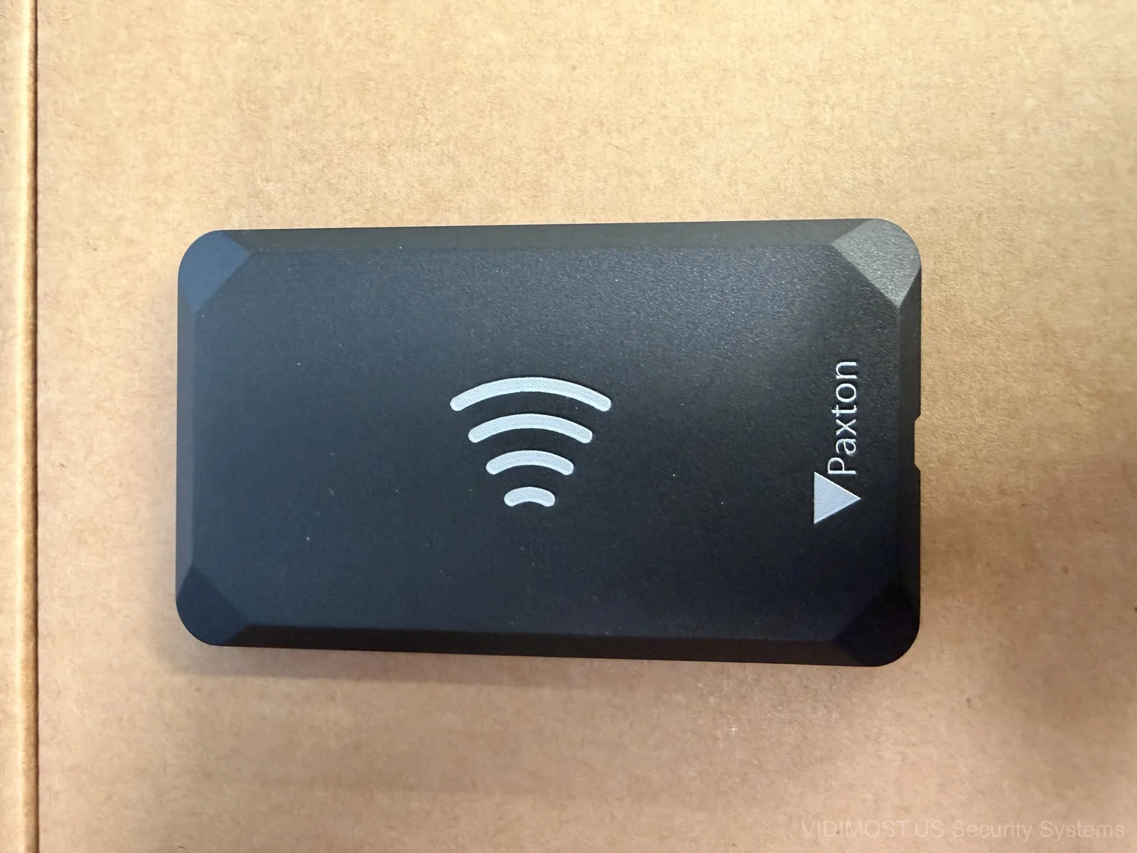 Paxton Solo NFC tag close-up showing the sleek black design with wireless symbol
